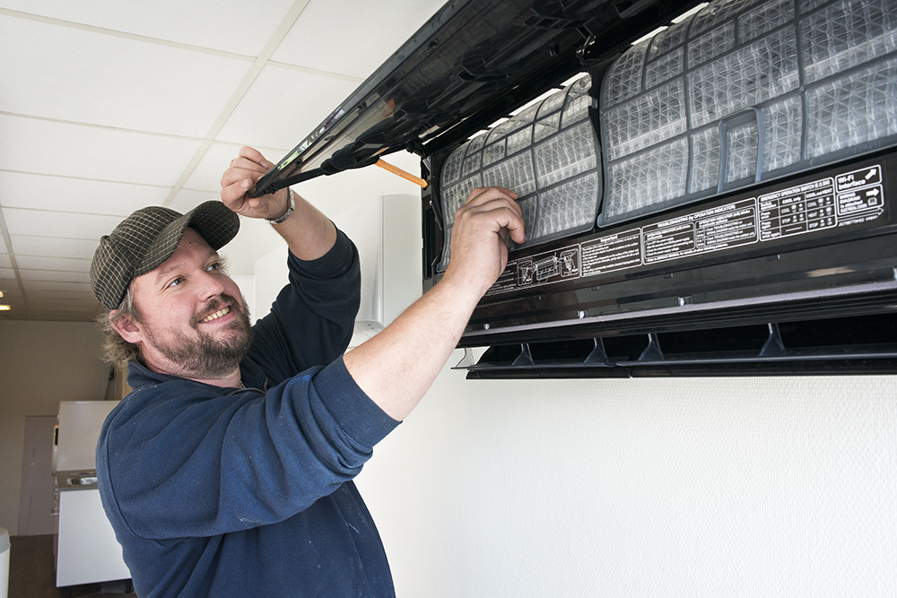 Rørlegger fra VVS Installatøren sjekker filter i varmepumpe